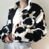 Person wearing a black and white cow print faux fur jacket.